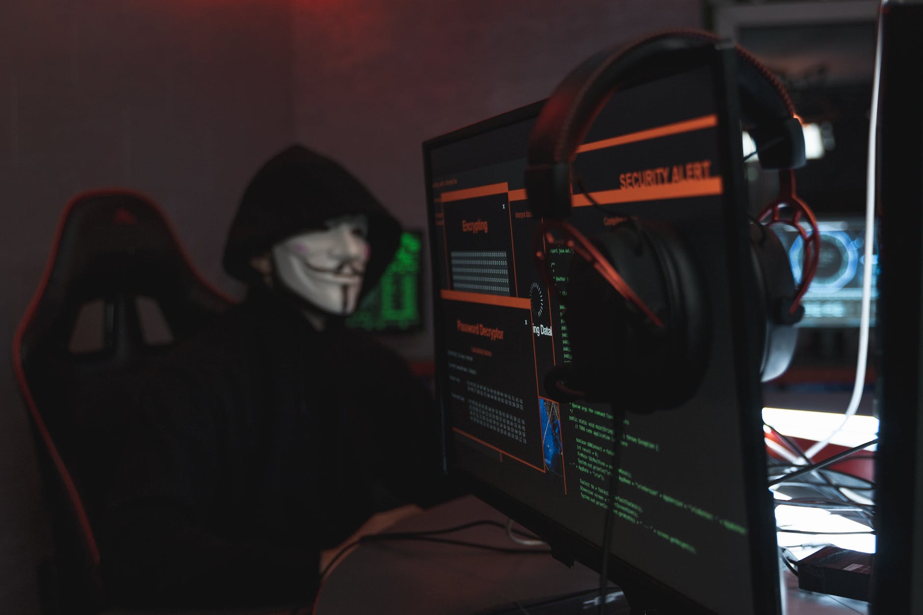 person in black hoodie hacking a computer system